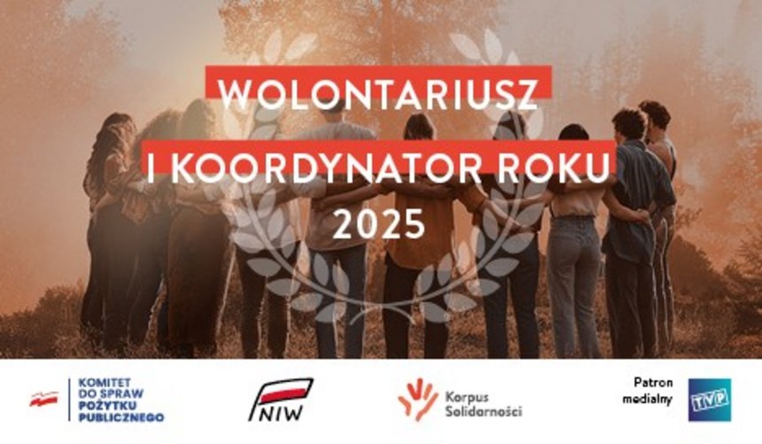 Zdjęcie w kolorach beżowo brązowych z białym napisem na czerwonym tle w centralnym punkcie zdjęcia. "WOLONTARIUSZ I KOORDYNATOR ROKU 2025. W tle grupa ludzi stojąca w kręgu i obejmująca się. W oddali widać drzewa rozpływające się we mgle.